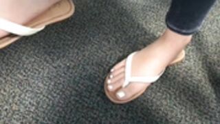 Arabic teen dangling flip flops in class