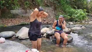 Dos mujeres se bañan en el río